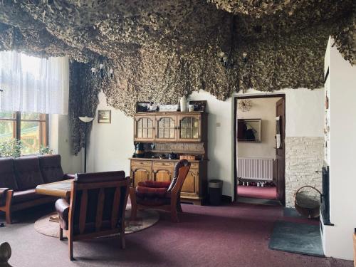 a living room with a table and chairs and a room with a ceiling at Stara Szkoła in Krempna