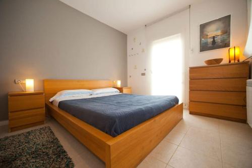 a bedroom with a wooden bed with a blue blanket at Casa Rosa de los Vientos, al lado de la playa in Sant Josep de Sa Talaia