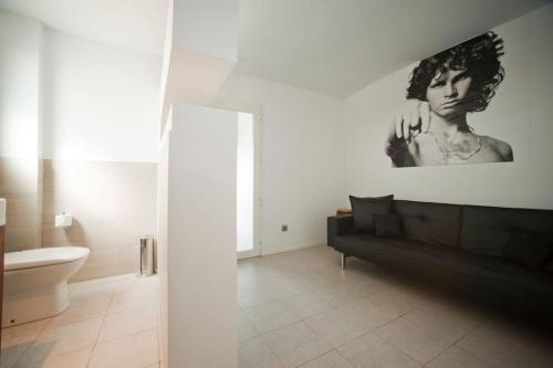 a bathroom with a black couch and a picture of a woman at Casa Rosa de los Vientos, al lado de la playa in Sant Josep de Sa Talaia