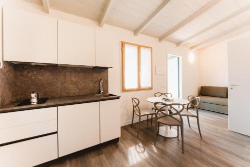 a kitchen with white cabinets and a table and chairs at Natural Village Resort in Porto Potenza Picena