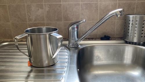 un lavello in acciaio inossidabile con un vaso da cucina di Kosher Tersefanou Larnaca a Larnaka