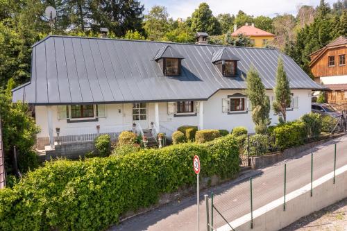 a white house with a metal roof at Villa Amalia, centrum Banska Stiavnica, parkovanie pre 2 auta, velka zahrada s krbom, cela Vila Superior pre 14 osob alebo samostatne prizemie Vila s vyhladom do zahrady pre 6 osob alebo samostatne podkrovie Vila Deluxe pre 8 osob - prístup cez PIN-kód in Banská Štiavnica