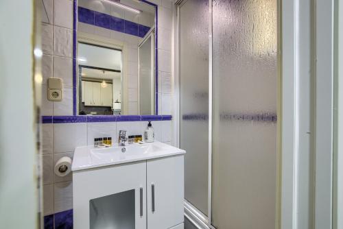 ein Badezimmer mit einem weißen Waschbecken und einer Dusche in der Unterkunft Charming Madrid Ferrocarril - Estancias Temporales in Madrid