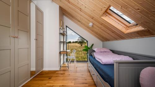 ein kleines Schlafzimmer mit einem Bett und einem Fenster in der Unterkunft Apartamenty Sun & Snow Sielska Stodoła z sauną in Trękus