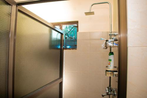 um chuveiro com uma porta de vidro na casa de banho em Gorgeous 4 Bedroom House ideal for Families and Large Groups em Boma la Ngombe