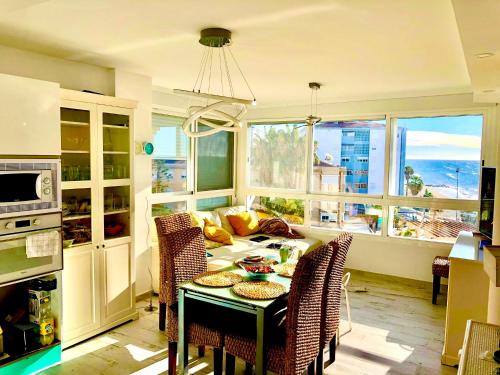 een keuken met een tafel en stoelen en een keuken met ramen bij Apartamento Vistas al mar in Algarrobo-Costa