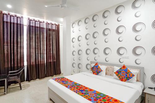 バラナシにあるFabHotel Siddhiのベッドルーム1室(ベッド1台付)、壁に皿を配したベッドルーム1室