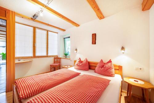 two beds in a room with red and white pillows at Mühlanderhof Apt Klopairspitze in Resia