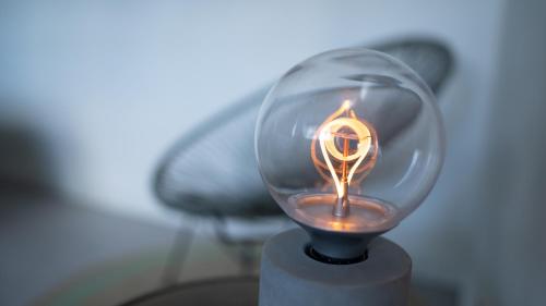 a candle is lit in a glass cup at Logement Overzee in Nes