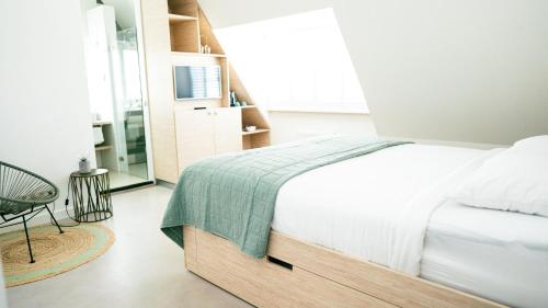 ein Schlafzimmer mit einem Bett mit einer grünen Decke in der Unterkunft Logement Overzee in Nes