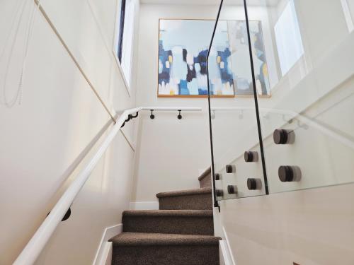 uma escada numa casa com um quadro na parede em Takapuna Brand new 3 Bedrooms em Auckland