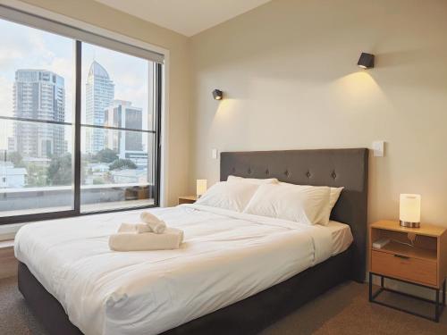 1 dormitorio con 1 cama grande y ventana grande en Takapuna Brand new 3 Bedrooms, en Auckland