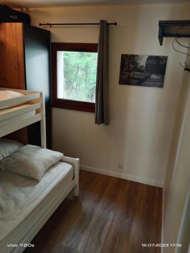 une chambre avec deux lits superposés et une fenêtre dans l'établissement T2 en résidence avec piscine, à Saint-Jean-de-Monts