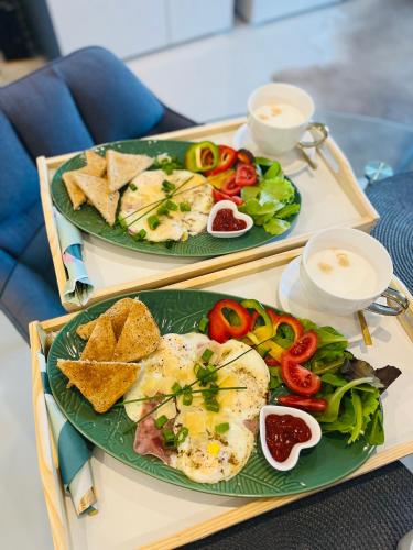 two plates of food on a tray with eggs and vegetables at Vila LEMAR wellness & spa in Huncovce