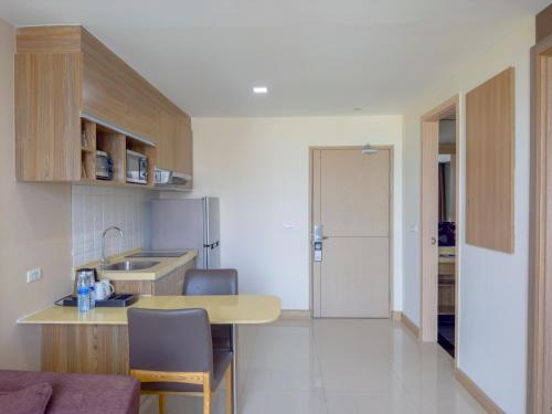 a small kitchen with a table and a counter top at Ramada Ekamai in Bangkok