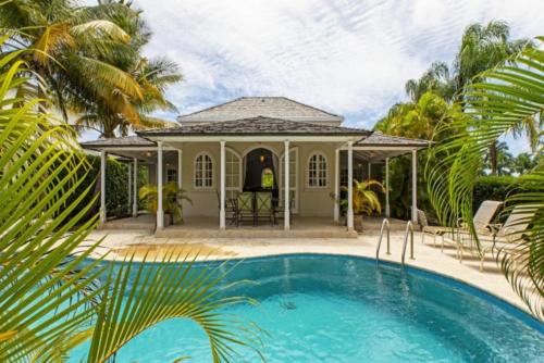 a house with a swimming pool and a gazebo at Palm Ridge 2A Heaven Scent, Royal Westmoreland by Barbados Sothebys International Realty in Saint James