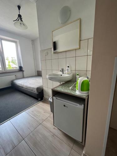 a bathroom with a sink and a bed in a room at Willa Strumyk in Karpacz