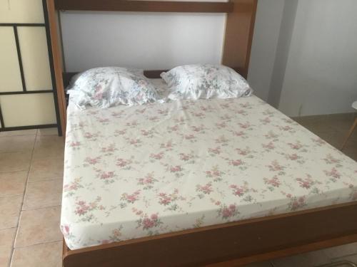 uma cama com uma colcha floral e almofadas em Loft 2 em La Trinité