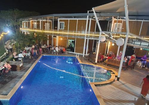 una piscina por la noche con un grupo de personas sentadas en Hi Creek Resort 