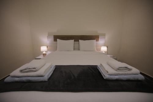 a bedroom with a large white bed with two lamps at OXYGEN Shekvetili in Shekvetili