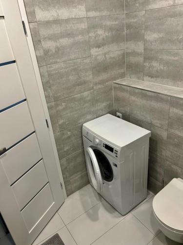 羅日尼亞瓦的住宿－1 Bedroom Apartment w/Balcony，卫生间旁的浴室内配有洗衣机。