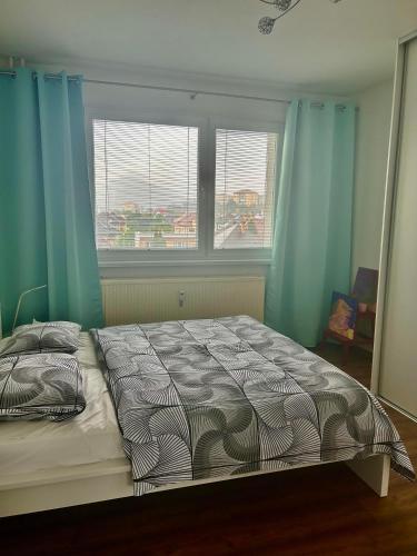 1 Schlafzimmer mit einem Bett und 2 Fenstern mit blauen Vorhängen in der Unterkunft 1 Bedroom Apartment w/Balcony in Rožňava