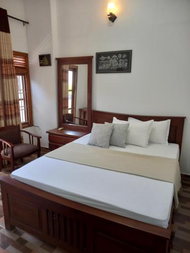a bedroom with a large bed with white sheets at Villa Luxez in Kalmunaikudiyiruppu