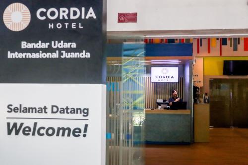 a woman sitting at a desk in an airport at Cordia Hotel Surabaya Airport - Hotel Dalam Bandara in Sidoarjo