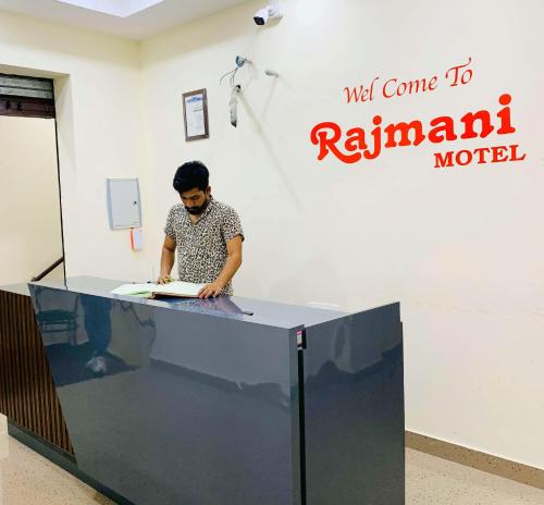um homem em pé diante de uma mesa com um papel em THE R MOTEL Phagwara City -- Full Privacy & Security -- Family,Corporate,Couples Favorite em Phagwāra