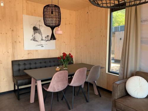 una sala da pranzo con tavolo e sedie di Luxe vakantielodge in Callantsoog aan zee a Callantsoog