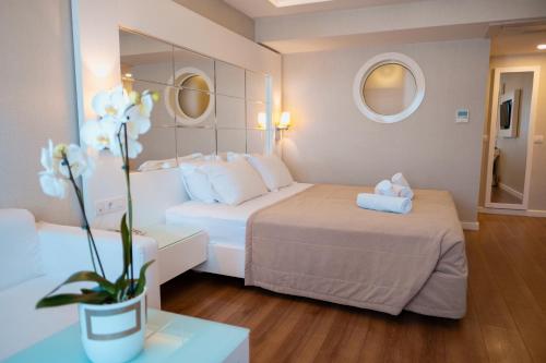 a hotel room with two beds and a vase with flowers at Alesta Residence in Fethiye