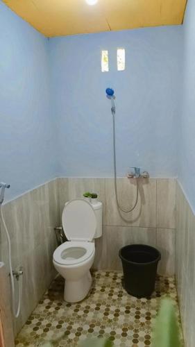 a bathroom with a toilet and a bucket at Alaya Villa in Bandungan