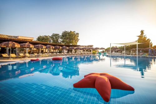 einen Pool mit roten Kissen im Wasser in der Unterkunft Valamar Tirena Hotel in Dubrovnik
