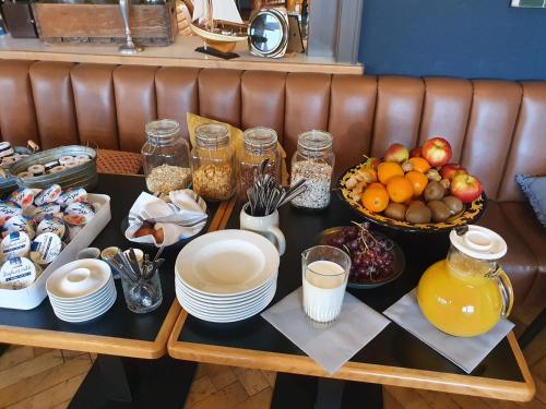 a table topped with plates and bowls of fruit at Hafen 17 Hotel Küche Bar in Kehl am Rhein