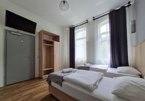 sypialnia z 2 łóżkami i telewizorem z płaskim ekranem w obiekcie Aparthotel Lenau w Hanowerze