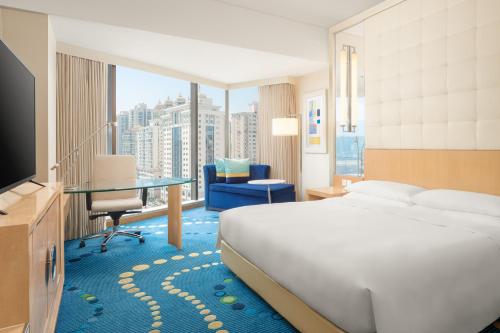 上海市にあるルネッサンス 上海 豫園 ホテルのベッド、デスク、テレビが備わるホテルルームです。
