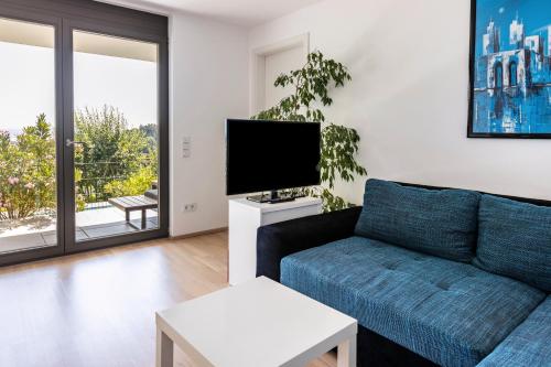 a living room with a couch and a flat screen tv at Am Lichtenberg in Daisendorf
