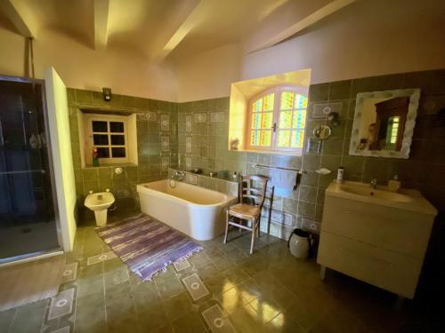 y baño con bañera, aseo y lavamanos. en La Frigoule, un gîte au cœur du parc des Cévennes, en Générargues