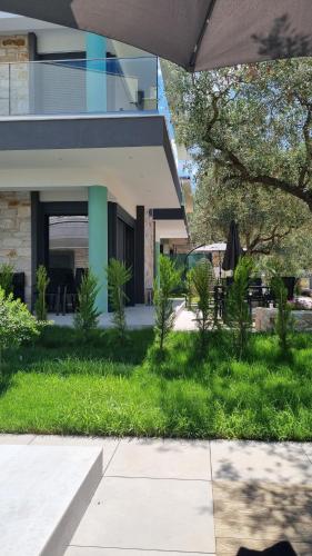 a house with a grassy yard next to a building at Danielli Luxury Villas in Skala Rachoniou
