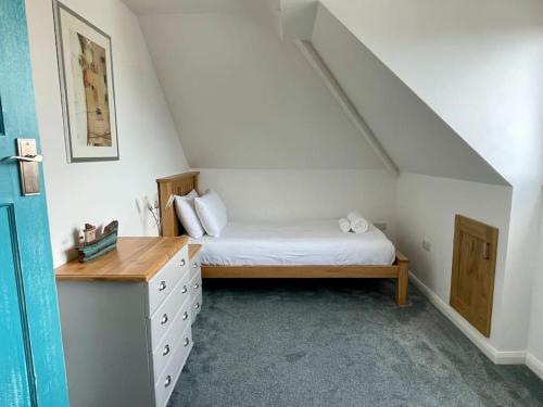 a bedroom with a bed and a dresser in a attic at Torquay holiday home near the sea in Torquay
