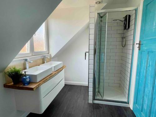 uma casa de banho com 2 lavatórios e uma cabina de duche em vidro. em Torquay holiday home near the sea em Torquay