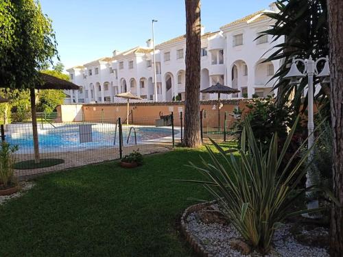 un complejo con piscina frente a un edificio en Apartamento La Caracola en Chiclana de la Frontera