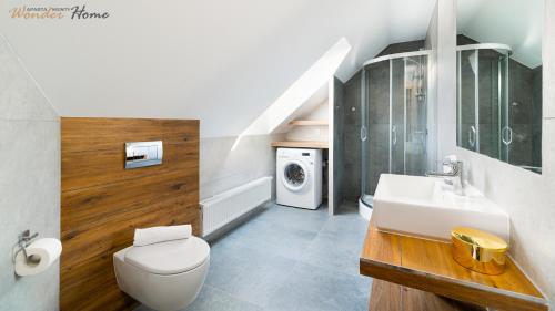 a bathroom with a white toilet and a sink at Wonder Home - Apartamenty w sercu Karpacza, blisko deptaka i terenów zielonych in Karpacz