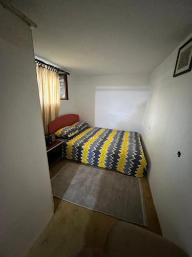 a small bedroom with a bed and a window at E & V free wi fi in Podgorica