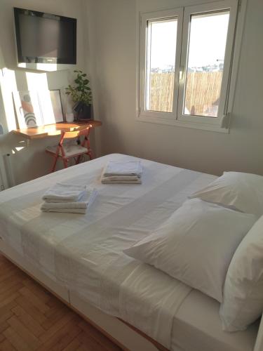 - un grand lit blanc dans une chambre avec 2 fenêtres dans l'établissement Eagle's Nest, à Athènes