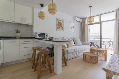 een keuken en een woonkamer met een bank en een tafel bij Apartamento Sunny Holidays in Puerto Rico de Gran Canaria