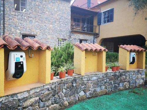 a stone retaining wall with pay phones on a building at La Meridiana ReIais & Chateaux in Garlenda