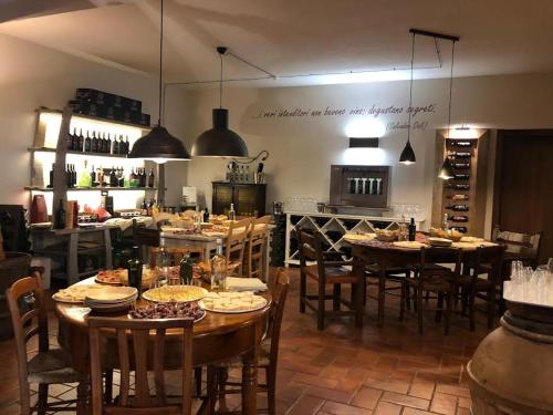 a restaurant with wooden tables and chairs and a kitchen at Wine Glamping Le Sedici in Massa Marittima