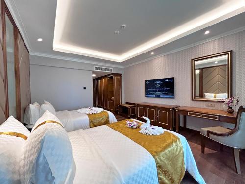 a hotel room with two beds and a desk at Damai Lagoon Resort in Santubong