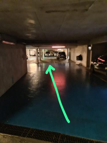 une flèche verte au sol d'un garage dans l'établissement Superbe Appartement 3 pièces près de la Défense, à Nanterre